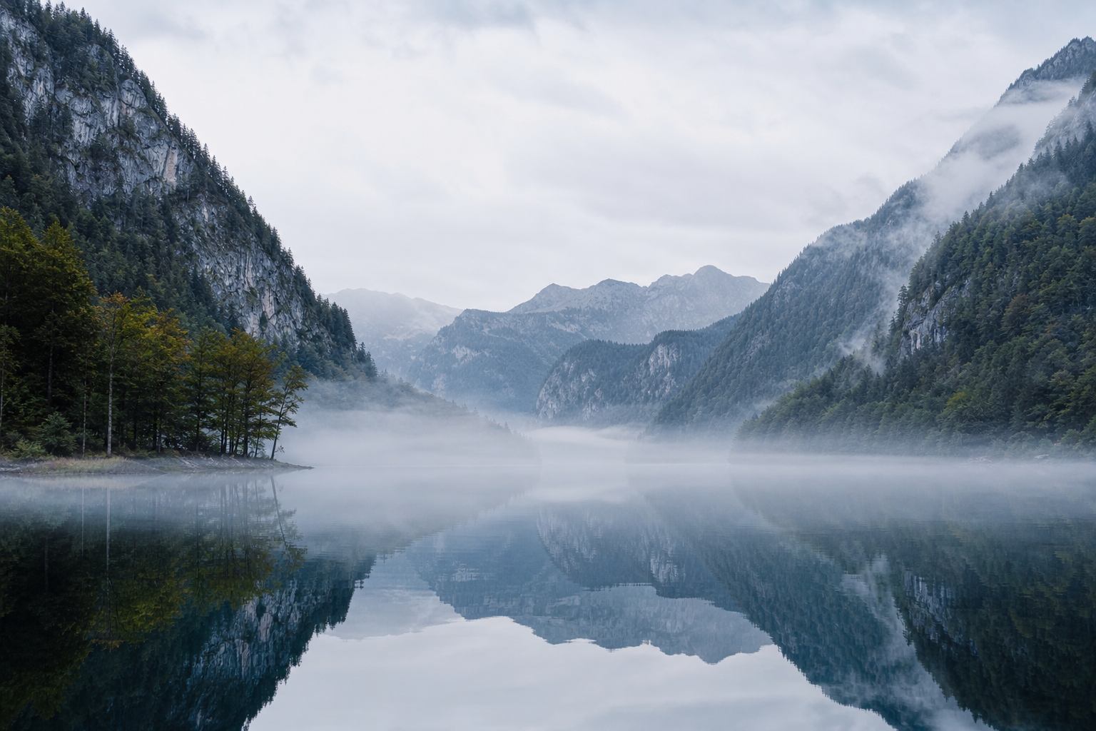Spiegelglatter Königssee in Berchtesgaden mit steilen Alpenwänden und Morgennebel